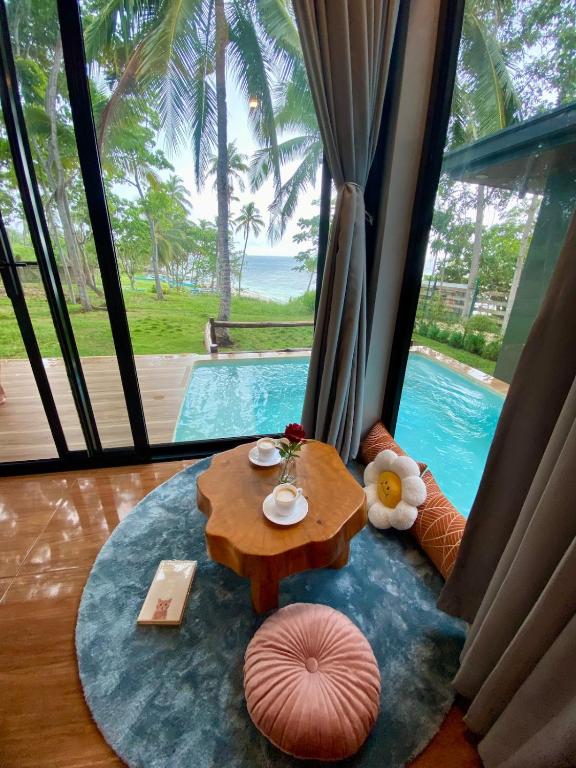 a living room with a table and a pool at Jako Doma Beachfront Cabana in San Francisco