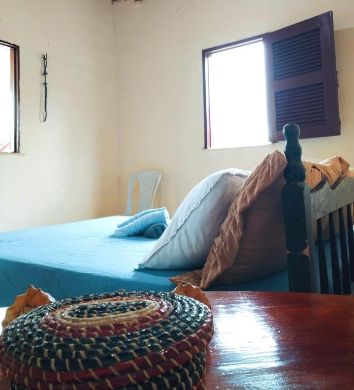 a bedroom with a bed and a wooden table at Aconchego Praia do Balbino in Cascavel