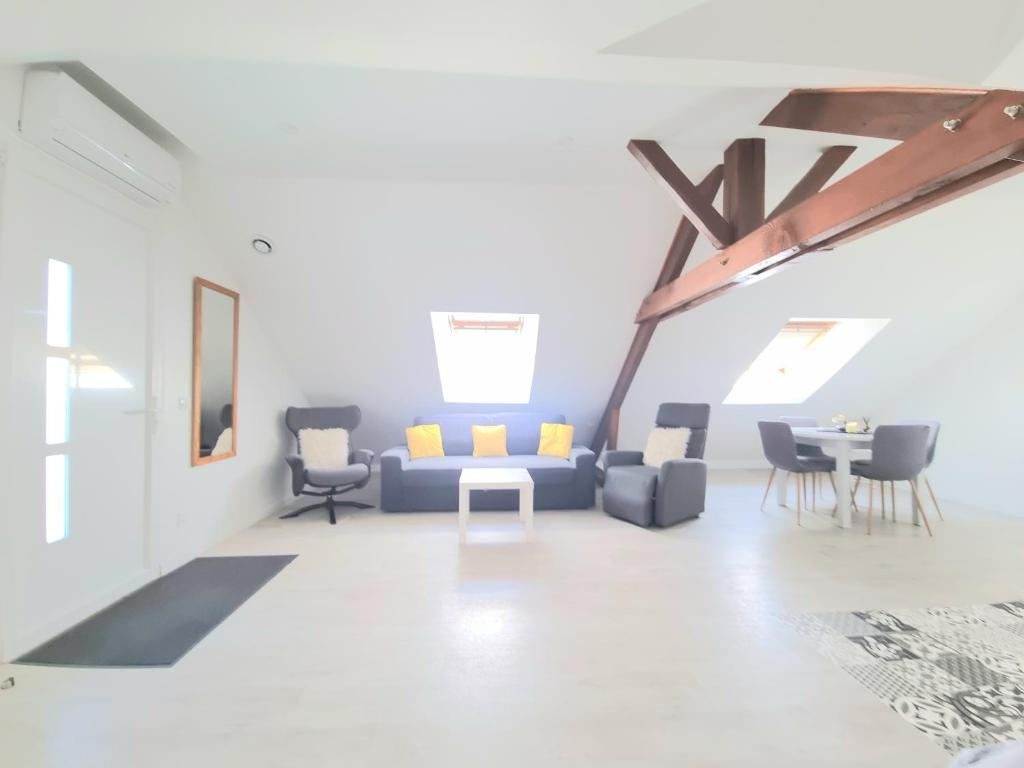 un salon avec un canapé bleu et des chaises dans l'établissement Appartement, proche Gare et Centre-Ville, à Blois