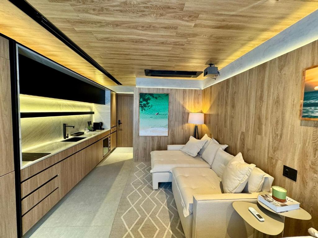 a living room with a couch and a flat screen tv at UNU 405 Loft Luxury Corredor da Vitória: piscina + in Salvador