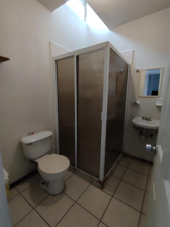 a bathroom with a toilet and a shower and a sink at Casa vacacional in Mazatlán