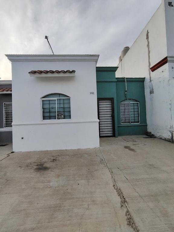 a white and green building with a window at Casa vacacional in Mazatlán