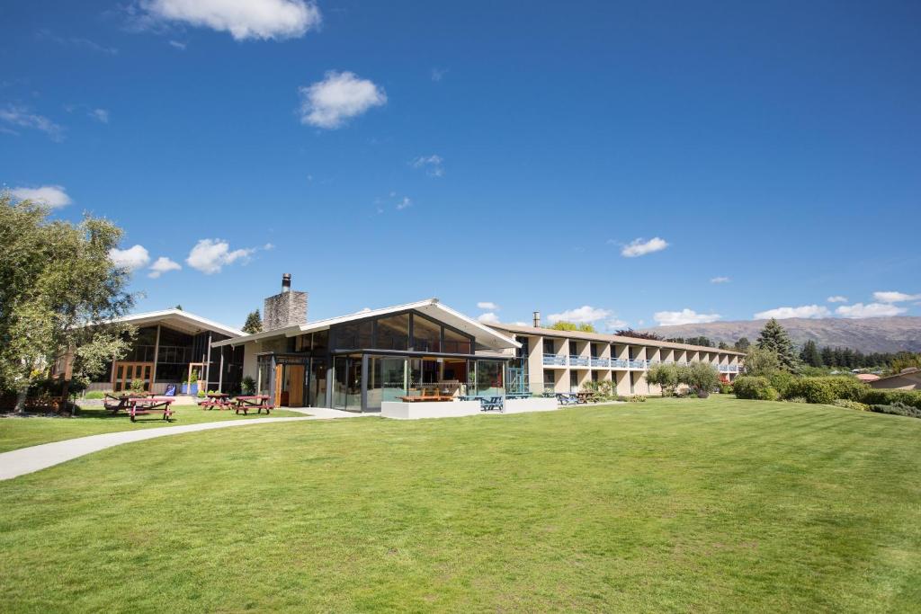 a building with a large lawn in front of it at Wanaka Hotel in Wanaka