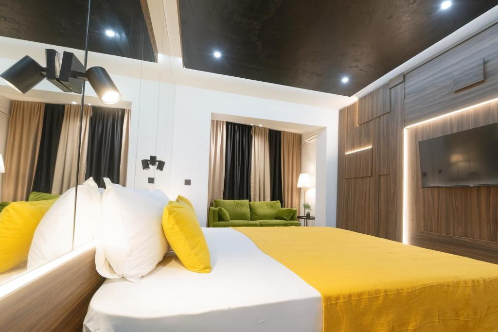 een slaapkamer met een bed met gele en witte kussens bij Central Belgrade Apartments in Belgrado