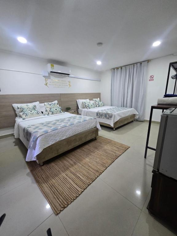 two beds in a room with two rugs at Hotel Rodadero Dorado in Santa Marta