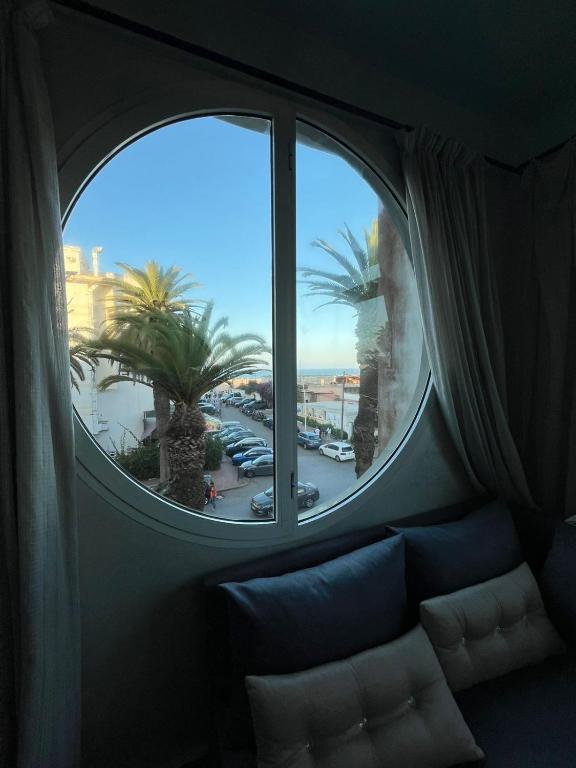a window in a room with a couch and palm trees at Apartment with sea view in Mohammedia