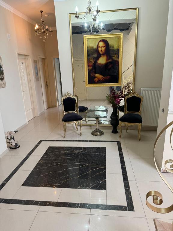 Una sala de estar con un cuadro y una mesa y sillas. en Aeroport Rooms, en Chişinău