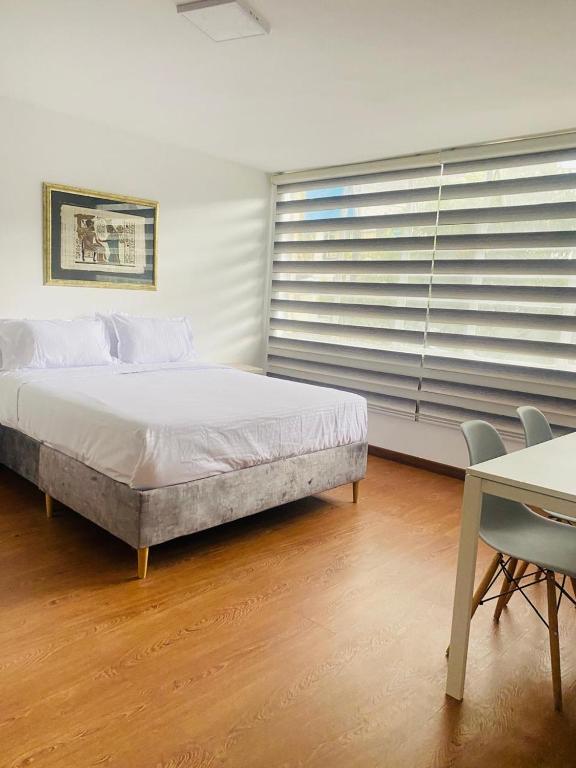 a bedroom with a bed and a table and chairs at Casa Boutique Punto 26 in Bogotá
