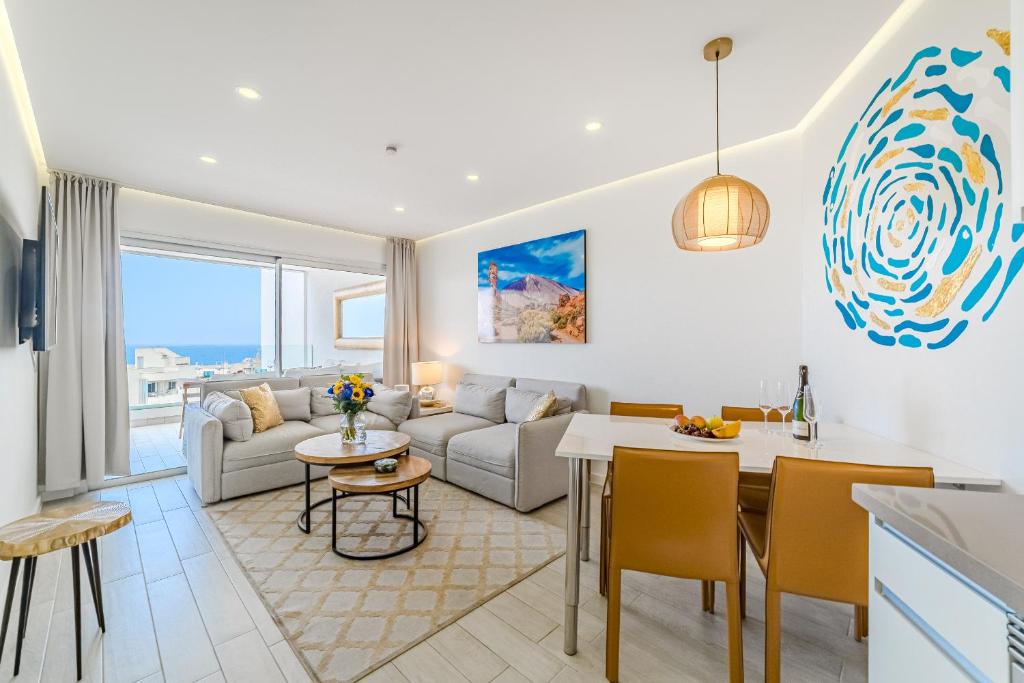 Una sala de estar y una cocina con un sofá y una mesa. en Blue Gold Escape in Ocean Garden, en Adeje