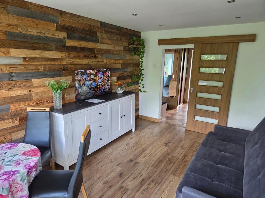 ein Wohnzimmer mit einer Wand mit Holzakzenten in der Unterkunft Apartament 3 pokoje in Słupsk