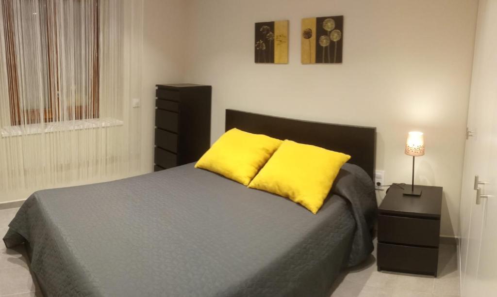 a bedroom with a bed with two yellow pillows at L'horitzó 0 in Llado