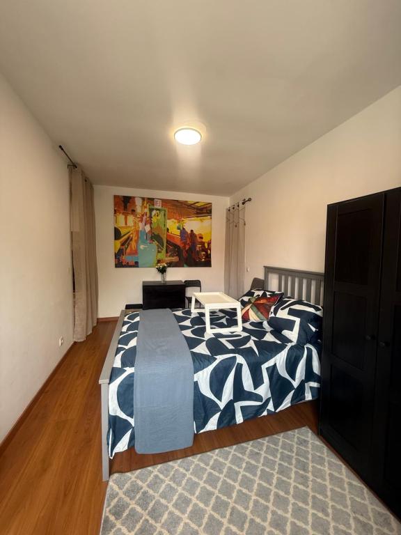 une chambre avec un lit avec une couverture bleue et blanche dans l'établissement Recanto em Carnide, à Lisbonne