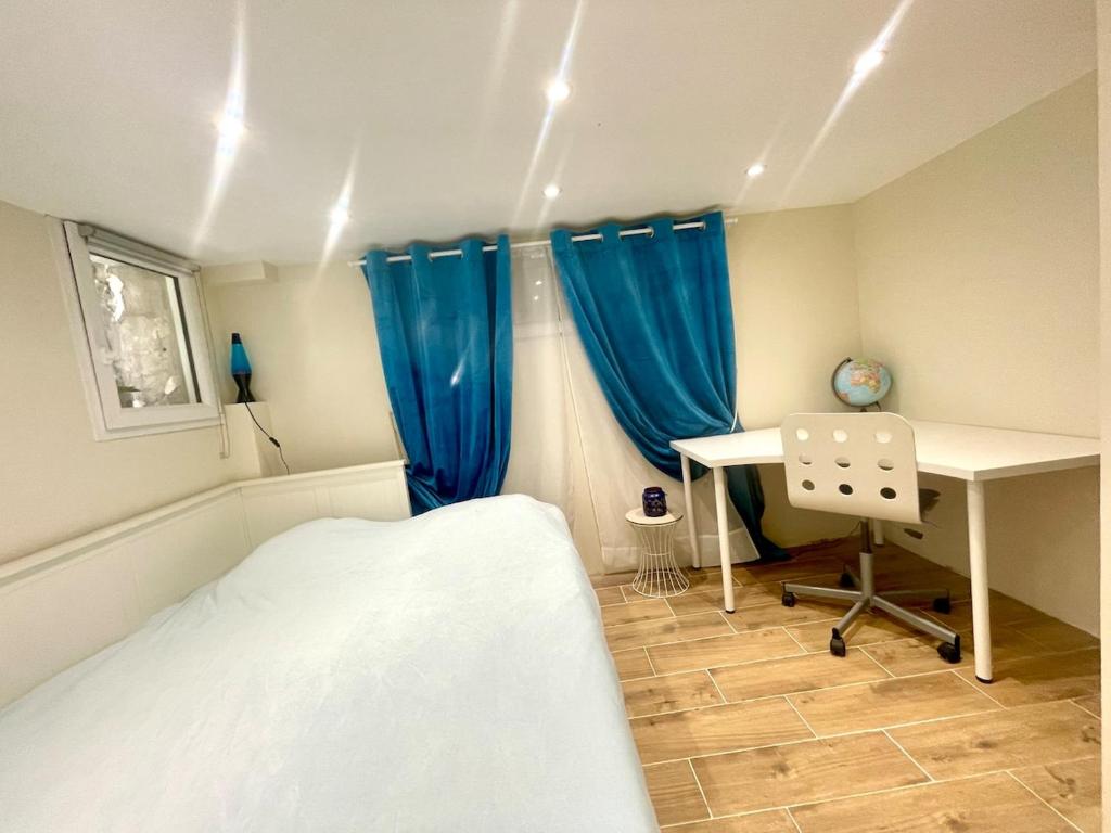 una camera con letto, scrivania e tende blu di Havre de Paix proche Paris et Disney a Saint-Maur-des-Fossés