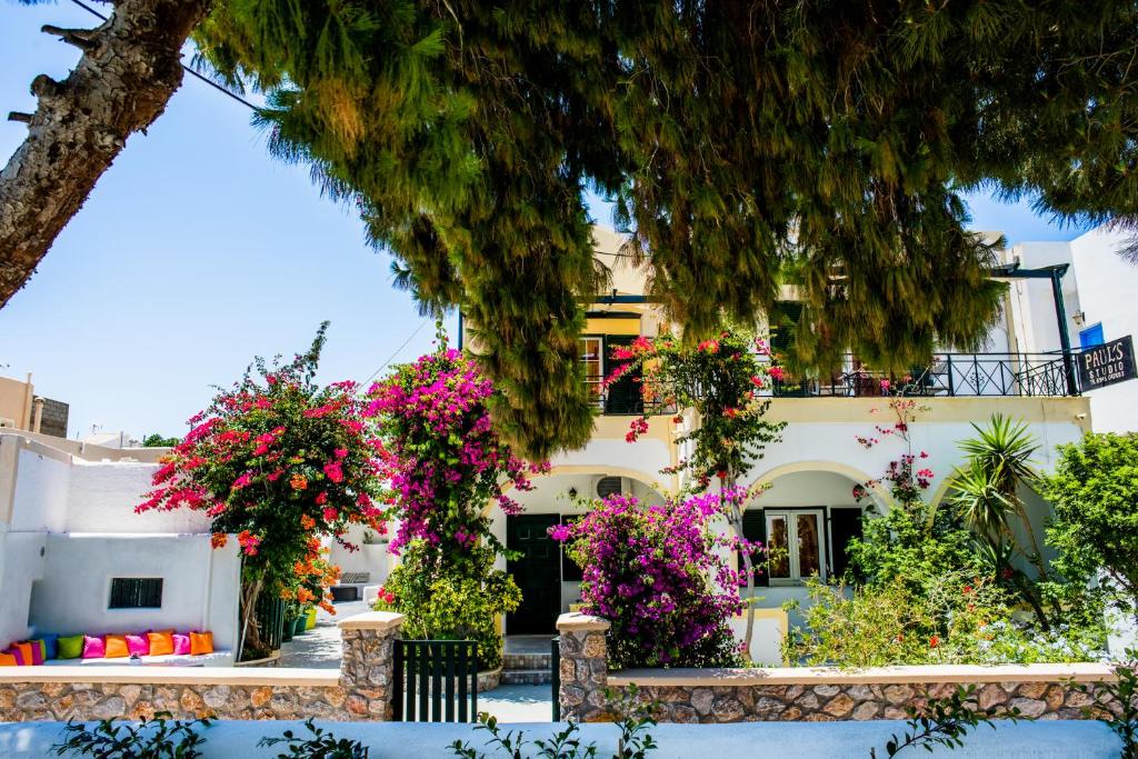 un bâtiment avec des fleurs devant lui dans l'établissement Studio Paul's, à Perissa