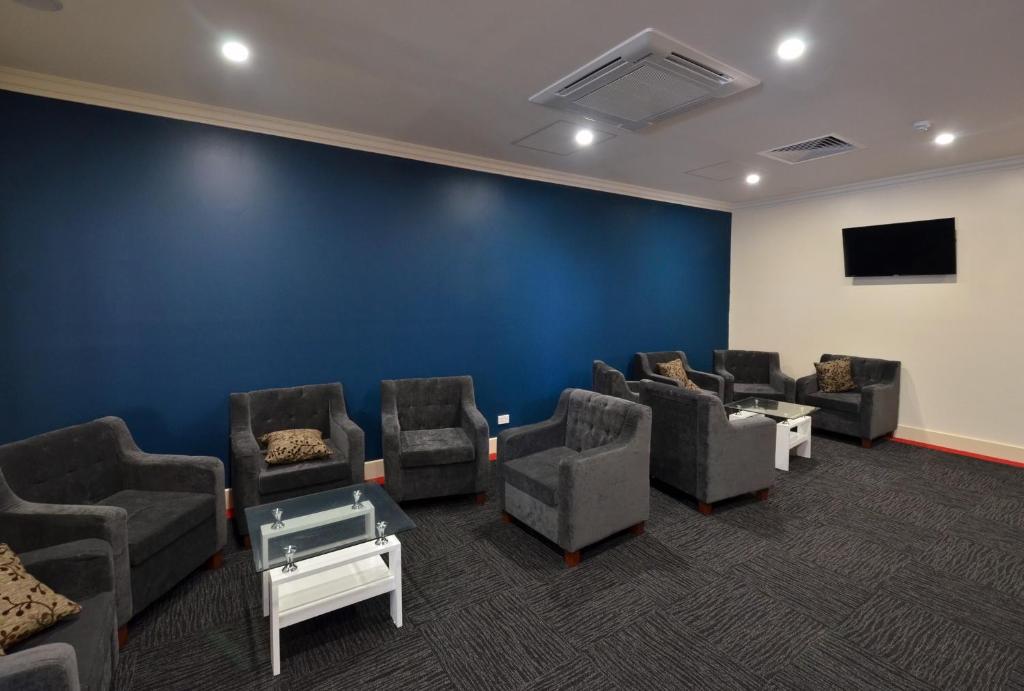 una sala d'attesa con sedie e una parete blu di Parklane Motel Murray Bridge a Murray Bridge