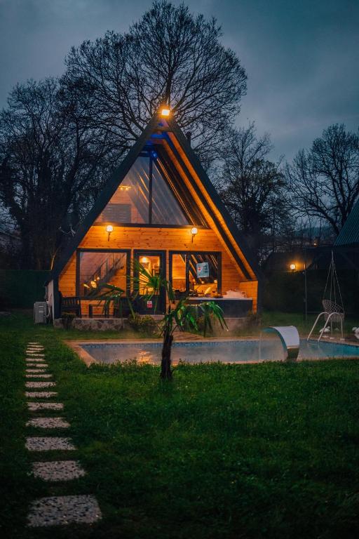 a large wooden house with a lit up roof at Sapanca Özfer Bungalov in Sapanca