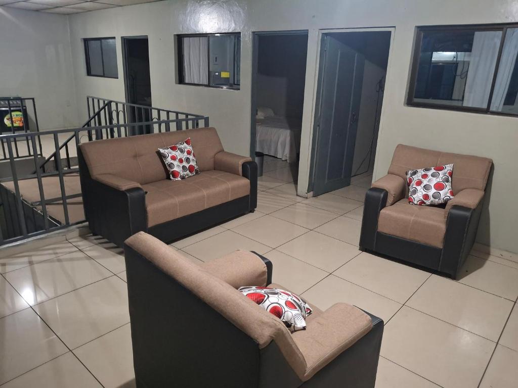Una sala de estar con sofás y sillas en una habitación. en Habitacion sencilla, en San Salvador