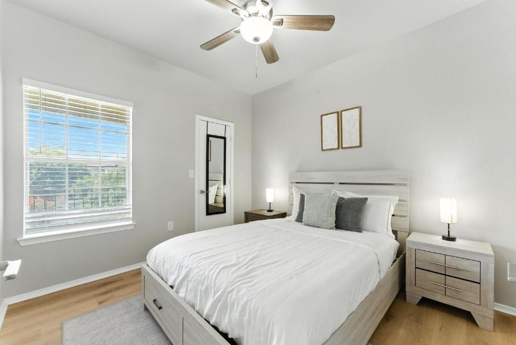 a white bedroom with a bed and a ceiling fan at The Calvin Spacious 334 I 2 Bed 1 Bath in Plano