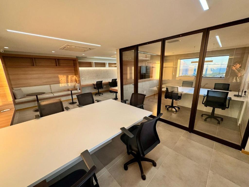 an office with a large white table and chairs at UNU 602 Itapuã: piscina, academia, praia e+ in Salvador