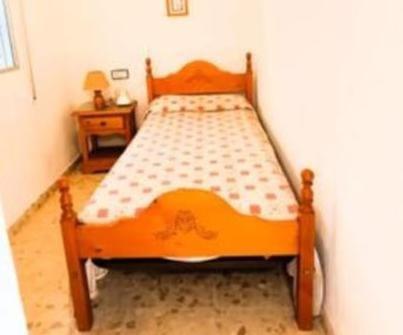 Una cama naranja en un dormitorio con una mesa. en Punta Umbria beach house, en Punta Umbría