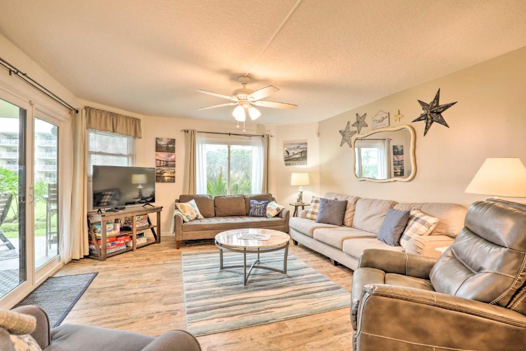 una sala de estar con un sofá y una mesa en St Augustine Beach Condo with Patio and Pool Access!, en Butler Beach