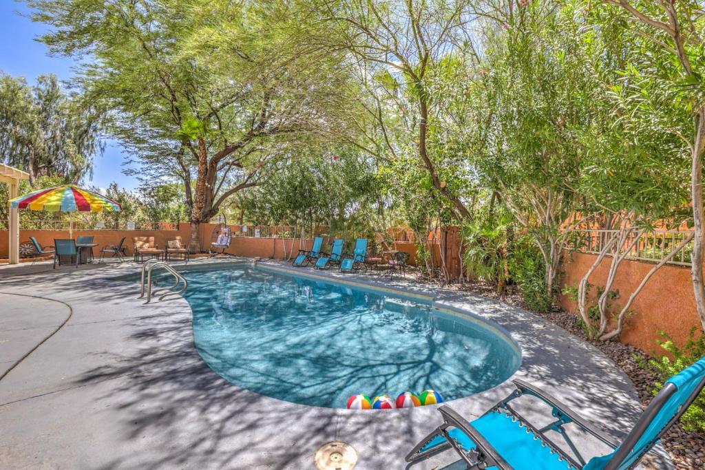 a swimming pool in a yard with chairs and trees at The Oasis At The Lakes in Las Vegas