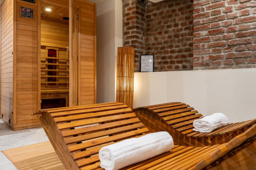 a wooden bench with towels sitting on top of it at Milano Wellness Suite - Spa, Sauna & Gym Experience in Milan