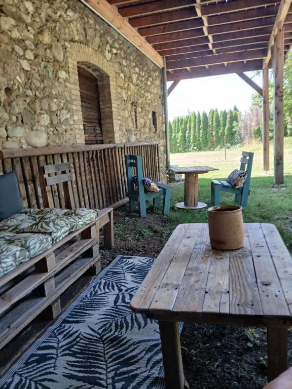 une table de pique-nique et des chaises assises sous un bâtiment dans l'établissement Les Gîtes du Saro, à Chabestan
