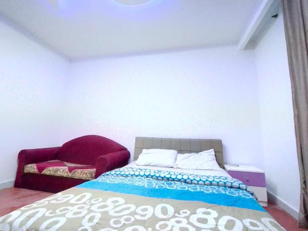 a bedroom with a bed and a red chair at delta porto sharm 102-25 in Sharm El Sheikh