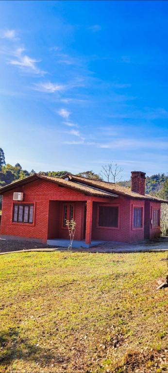 南圣克鲁斯hotel fazenda ctk的前面有草地的红色房子