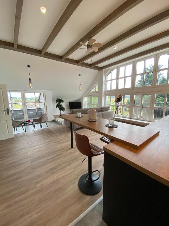 a large room with a table and chairs and windows at Hengstresort Velten in Velten