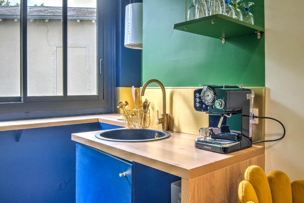 une cuisine avec un mélangeur sur un comptoir avec un évier dans l'établissement Chez Joséphine au Petit Palais, à Périgueux