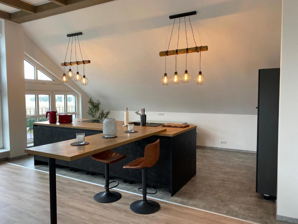 an open kitchen with a wooden table and chairs at Hengstresort Velten in Velten