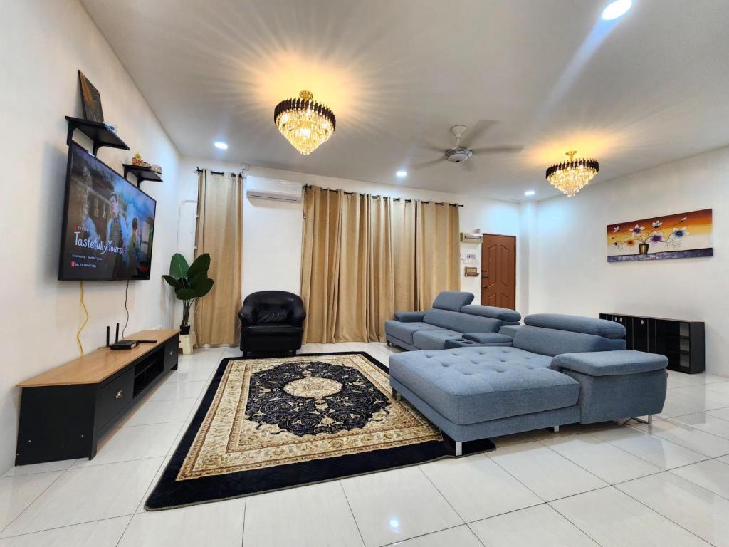 a living room with a couch and a flat screen tv at Dirgahayu Homestay I Rajawali in Kulim