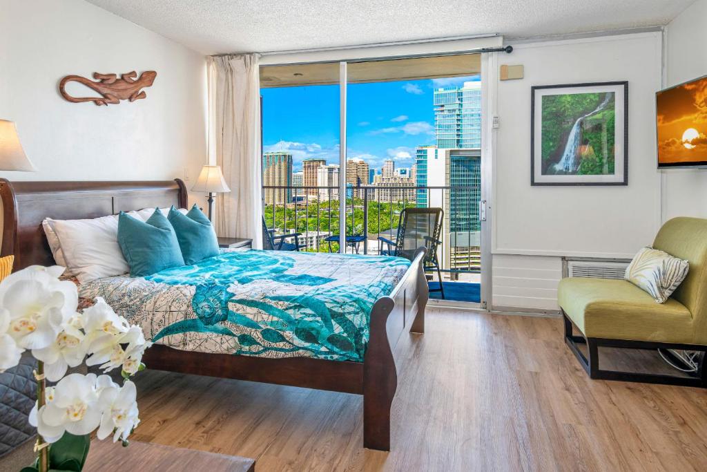 a bedroom with a bed and a large window at Renovated Condo Near Waikiki Beach in Honolulu