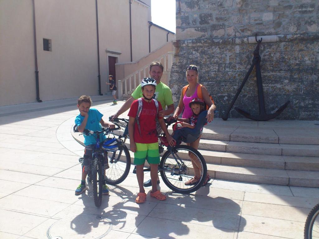 una familia posando para una foto con sus bicicletas en Adriatic Houses Borse, en Bašanija