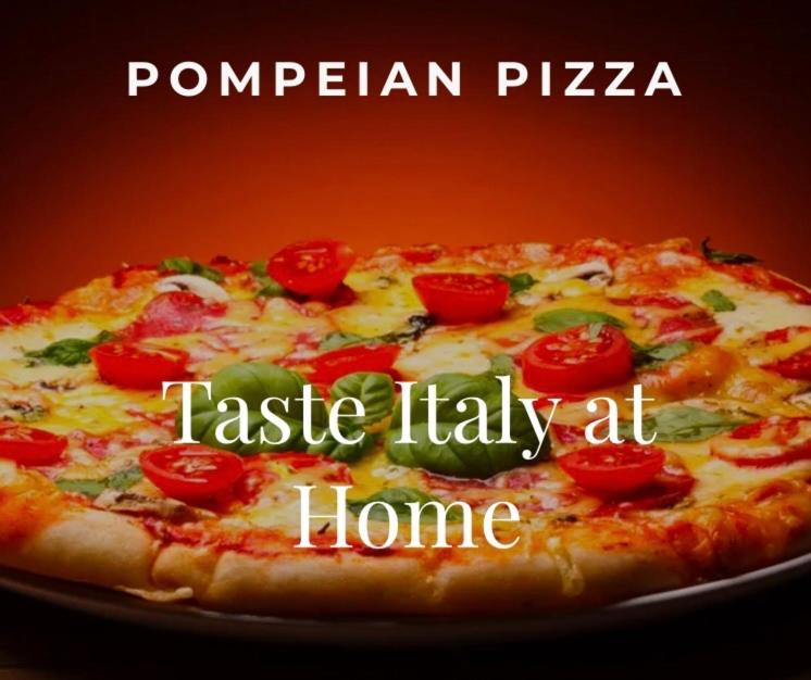 a pizza on a plate with tomatoes on it at Pompeian Pizza in Puerto Vallarta