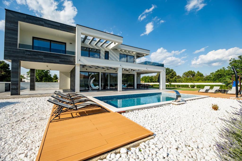 a home with a swimming pool and a house at Contemporary Zadar Villa 4 Bedrooms Villa Barako Prestige in Nin