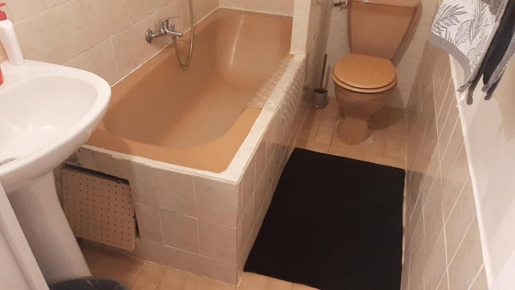 a bathroom with a tub and a toilet and a sink at Appartement F3 Caracosy tout confort in Les Abymes