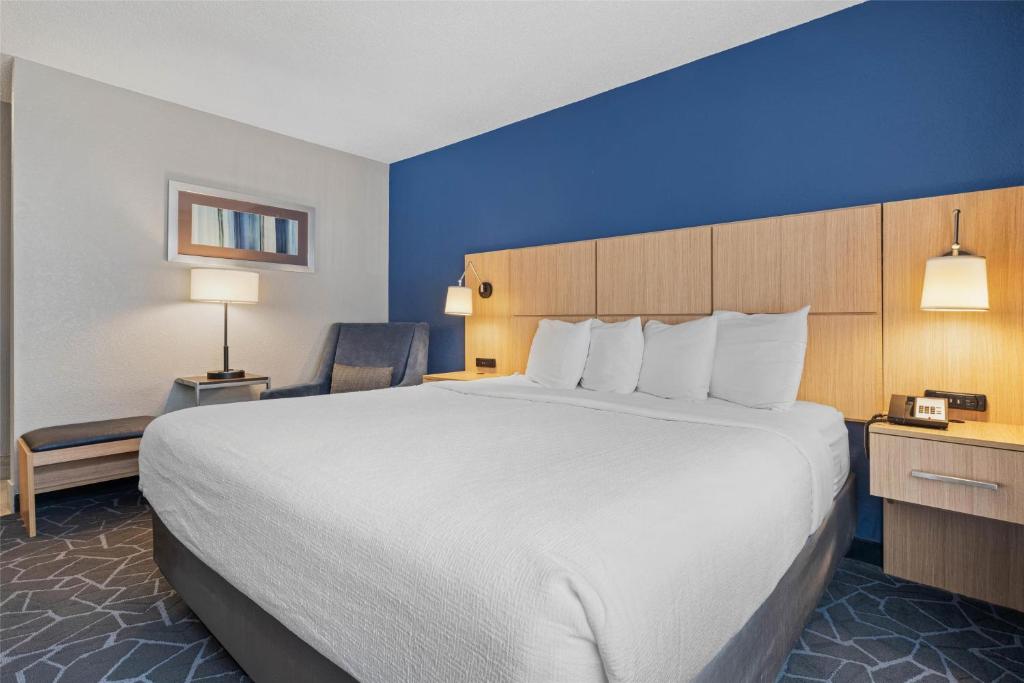 a hotel room with a large bed and a blue wall at Best Western Eau Claire South in Eau Claire