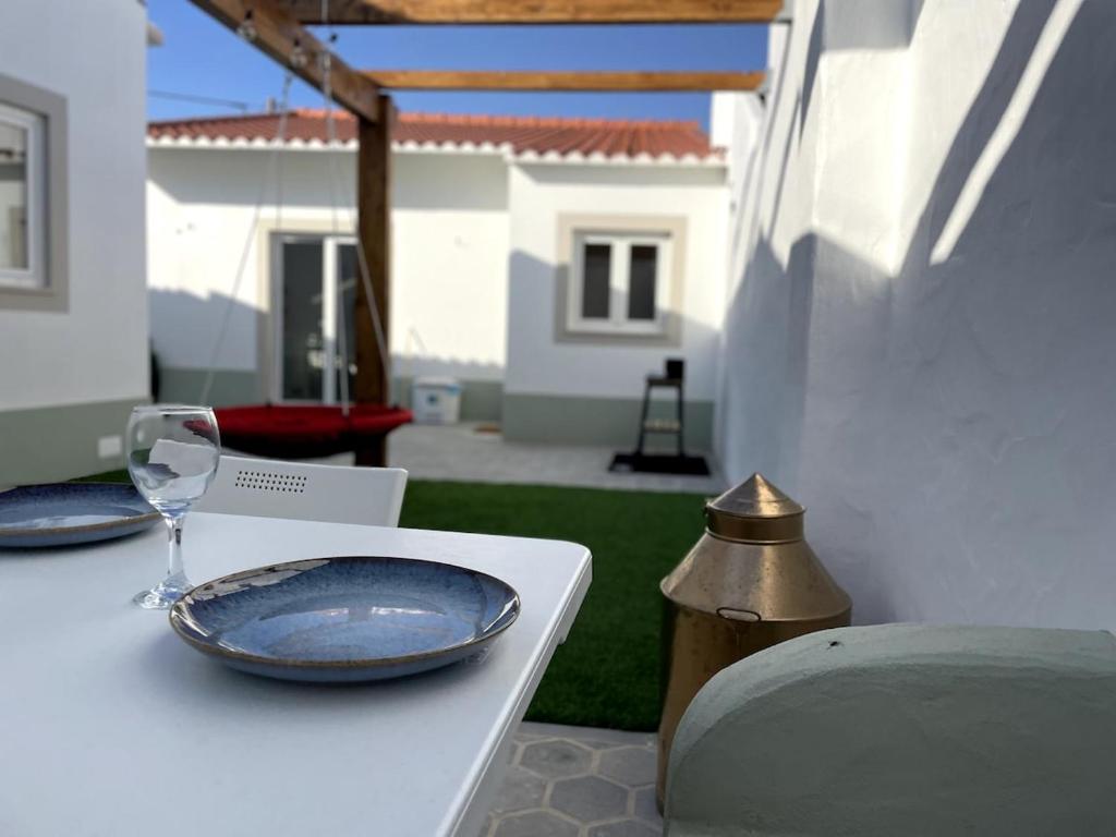 a white table with two plates and a glass at Casa da Avó Lu in Assentiz
