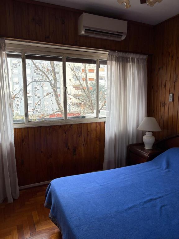 a bedroom with a blue bed and a window at Departamento de 3 ambientes in La Porteña