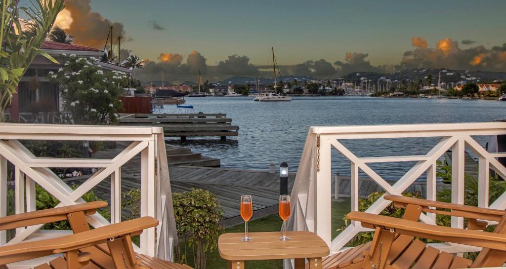 two glasses of wine sitting on a deck with a view of the water at The Harbour #6 - 2 Bedrooms in Rodney Bay townhouse in Gros Islet