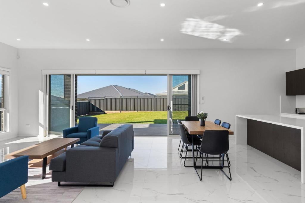 Una sala de estar con un sofá, una mesa y sillas. en Cork & Vine on Coolalta - A Cellar Door Escape, en Nulkaba