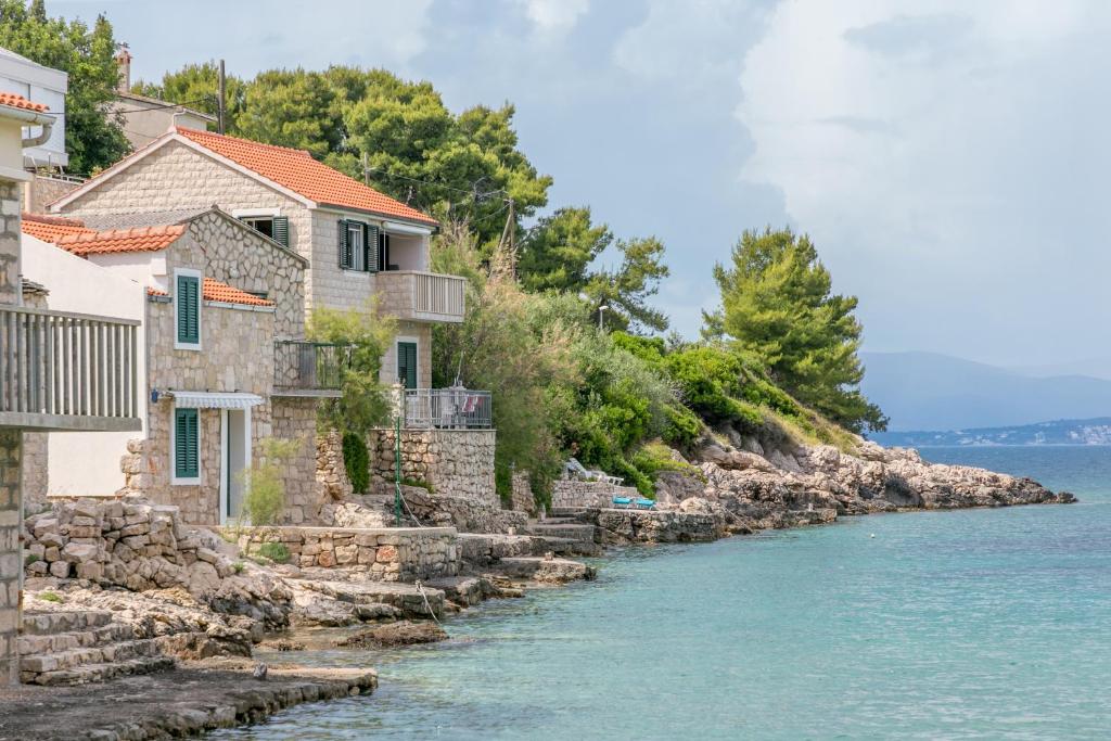 a row of houses next to the water at Apartments by the sea Cove Donja Kruscica - Donja Krusica, Solta - 11146 in Grohote