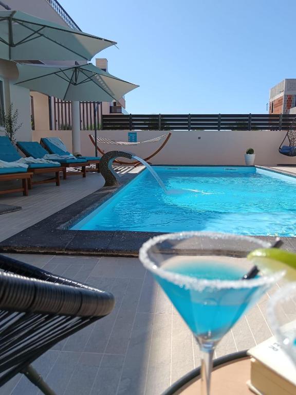 a drink sitting on a table next to a swimming pool at Holiday&Suite Klanac in Vir