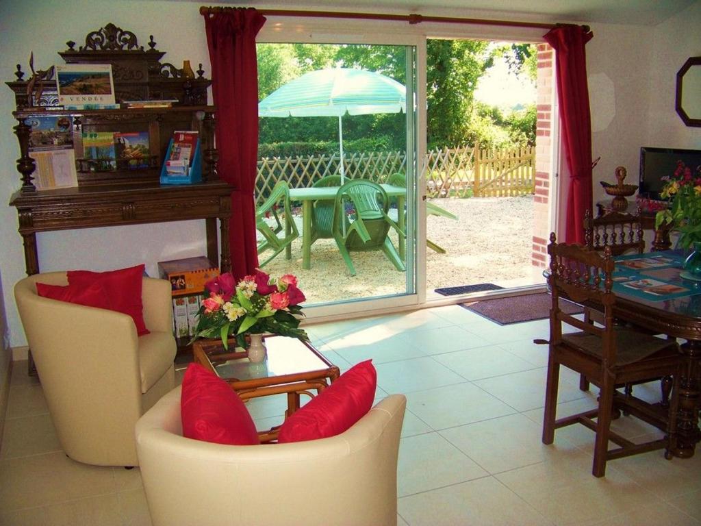 sala de estar con mesa, sillas y sombrilla en Gîte authentique avec terrasse, jardin clos et wifi à La Garnache - FR-1-426-140, en La Garnache