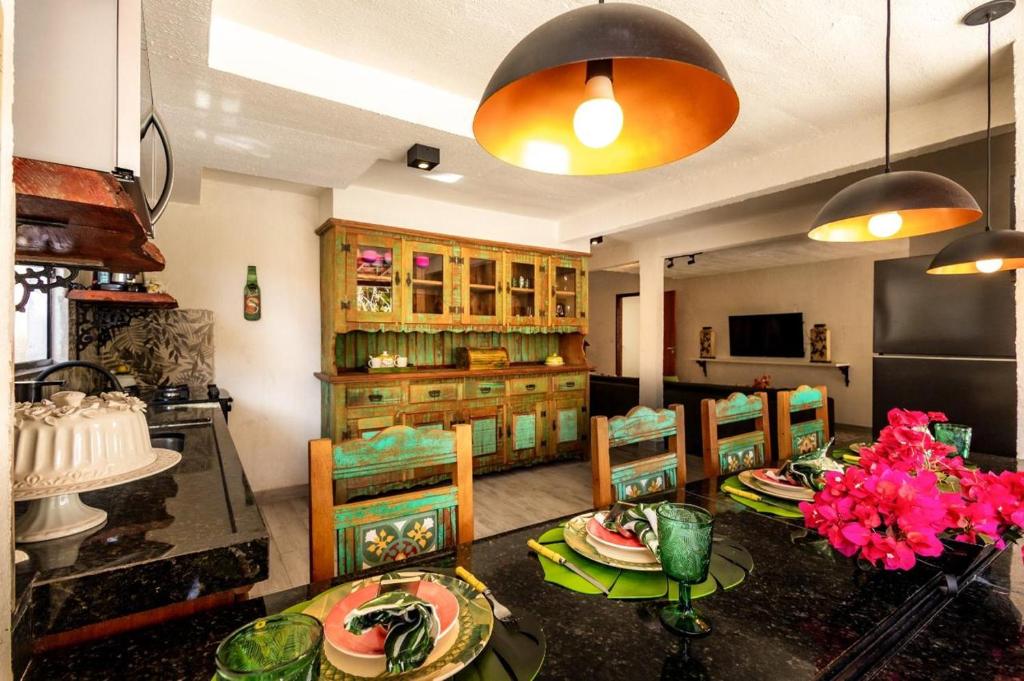 a kitchen with a table with chairs and a dining room at Casa Villa Fontana - Condomínio à beira-mar e próximo ao aeroporto - Praia de Itapuã in Salvador