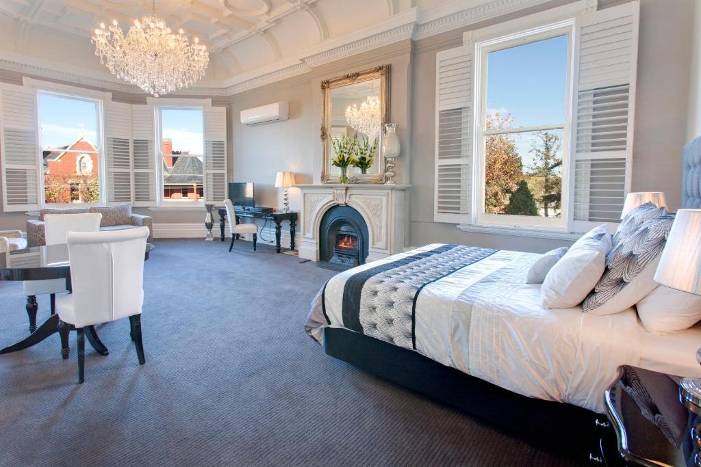 a bedroom with a king sized bed and a dining room at Ballarat Premier Apartments in Ballarat