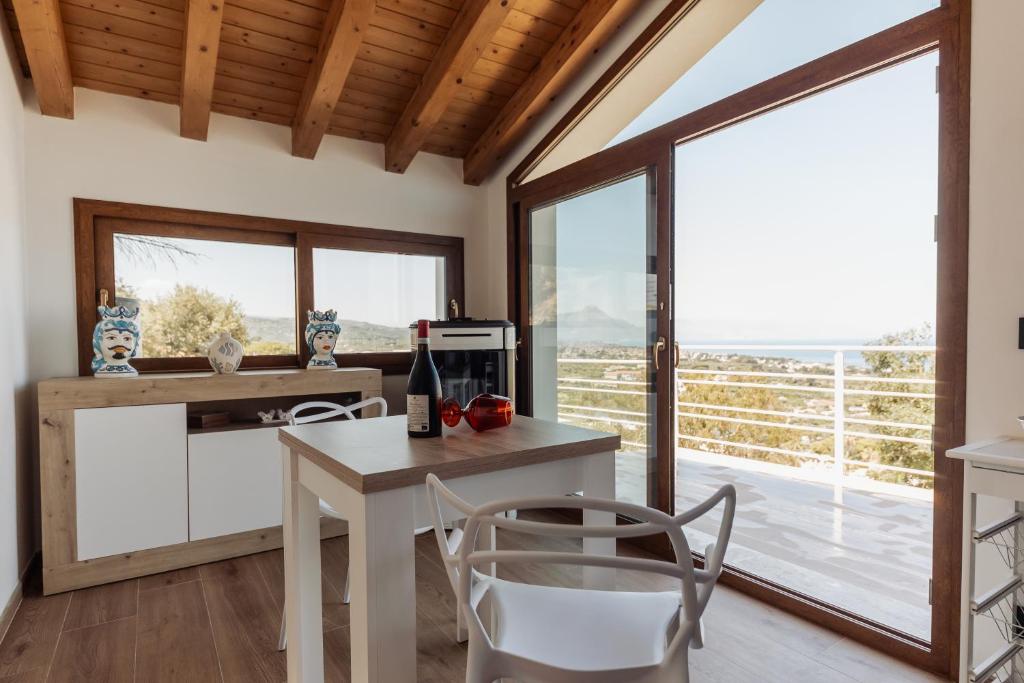 a kitchen with a table and chairs and a large window at Villa Michela - Dimora di Charme a Cefalù con panorama sul mare in Cefalù